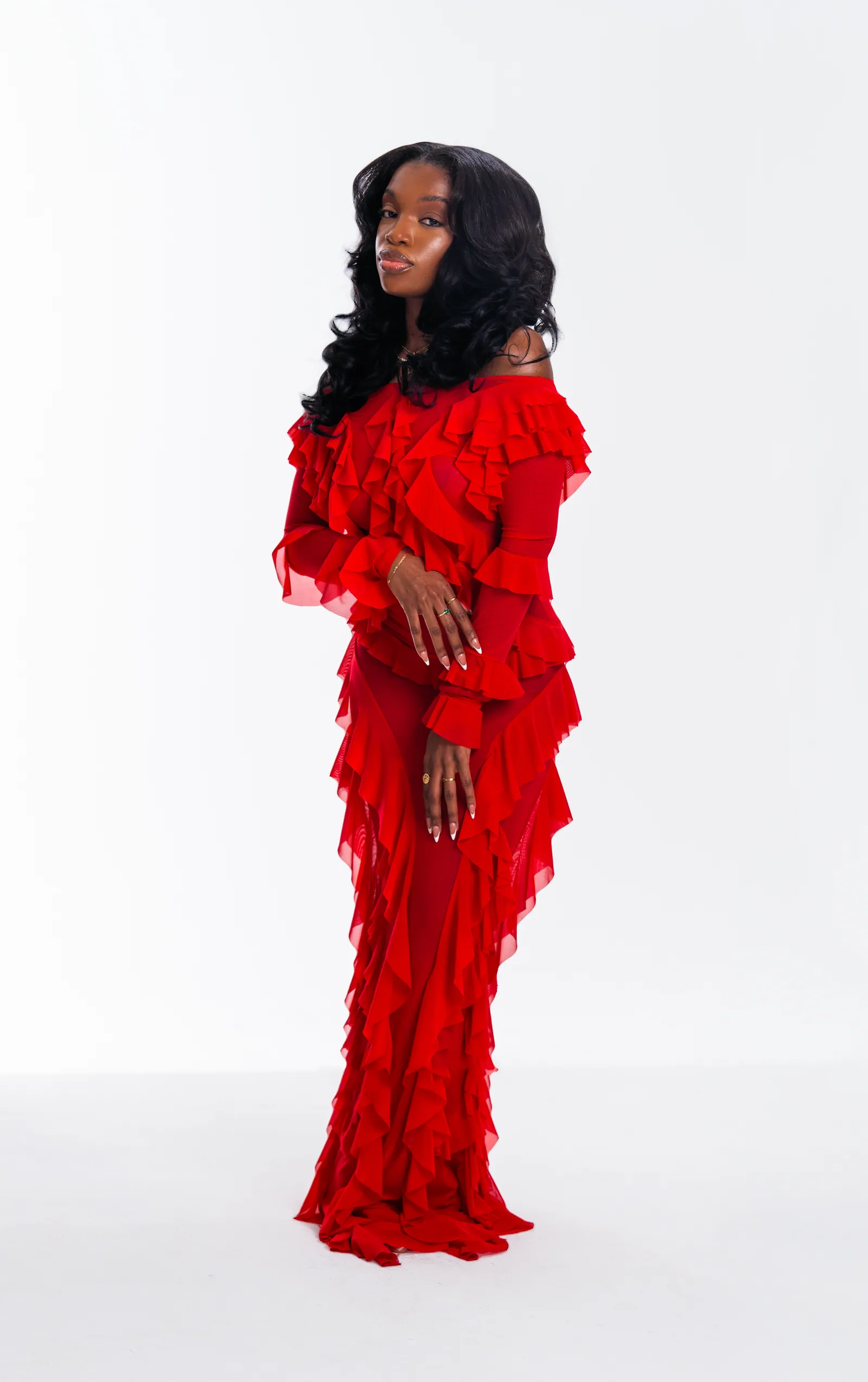 Studio portrait in a red ruffled gown on white seamless